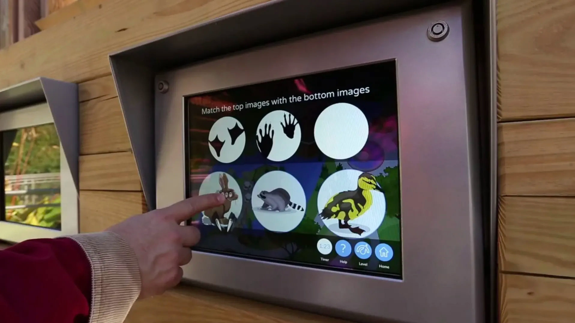 Child interacting with a touchscreen matching game in the Children's Adventure Garden